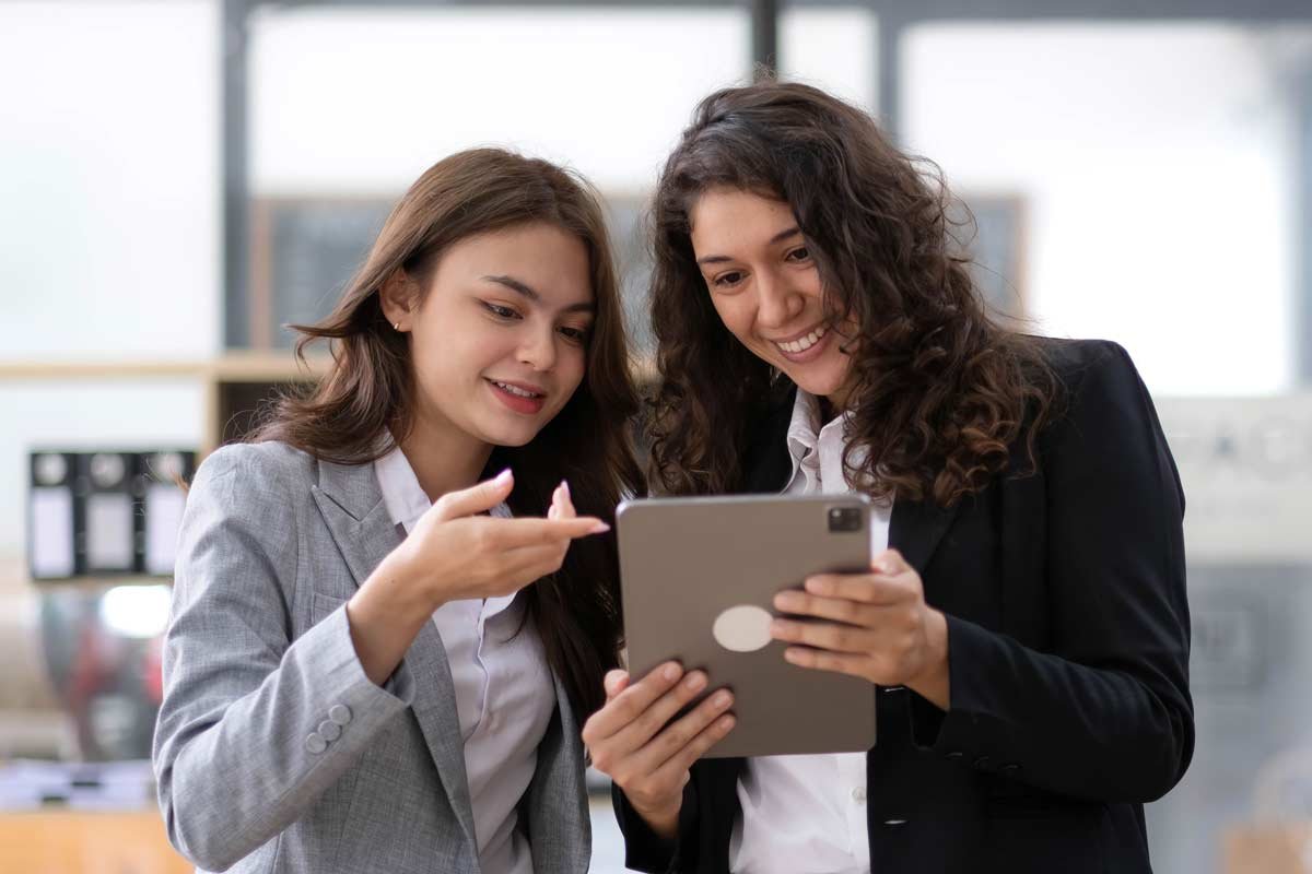 Women in tech collaborate on UI review with tablet