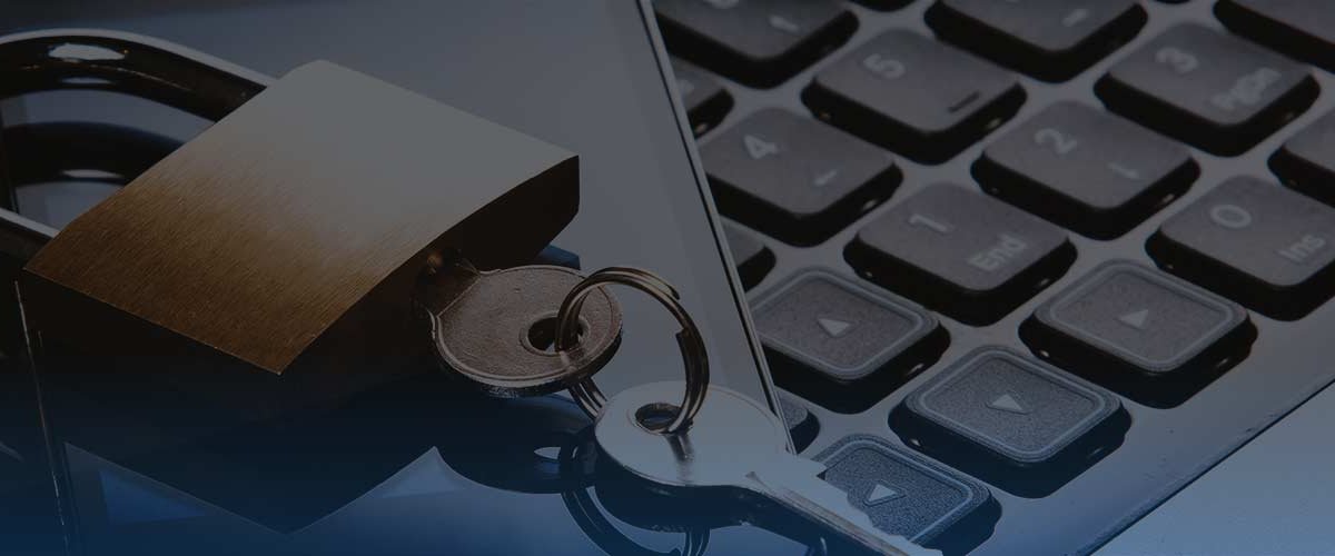 Lock and key on phone on top of laptop keyboard