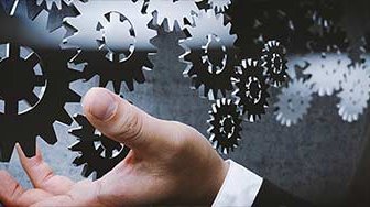 Series of gears floating in front of business man