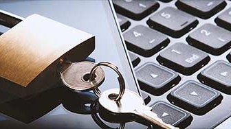 Lock and key on top of photo screen lying on laptop keyboard