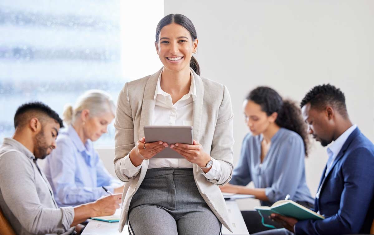Woman with tablet at meeting with team