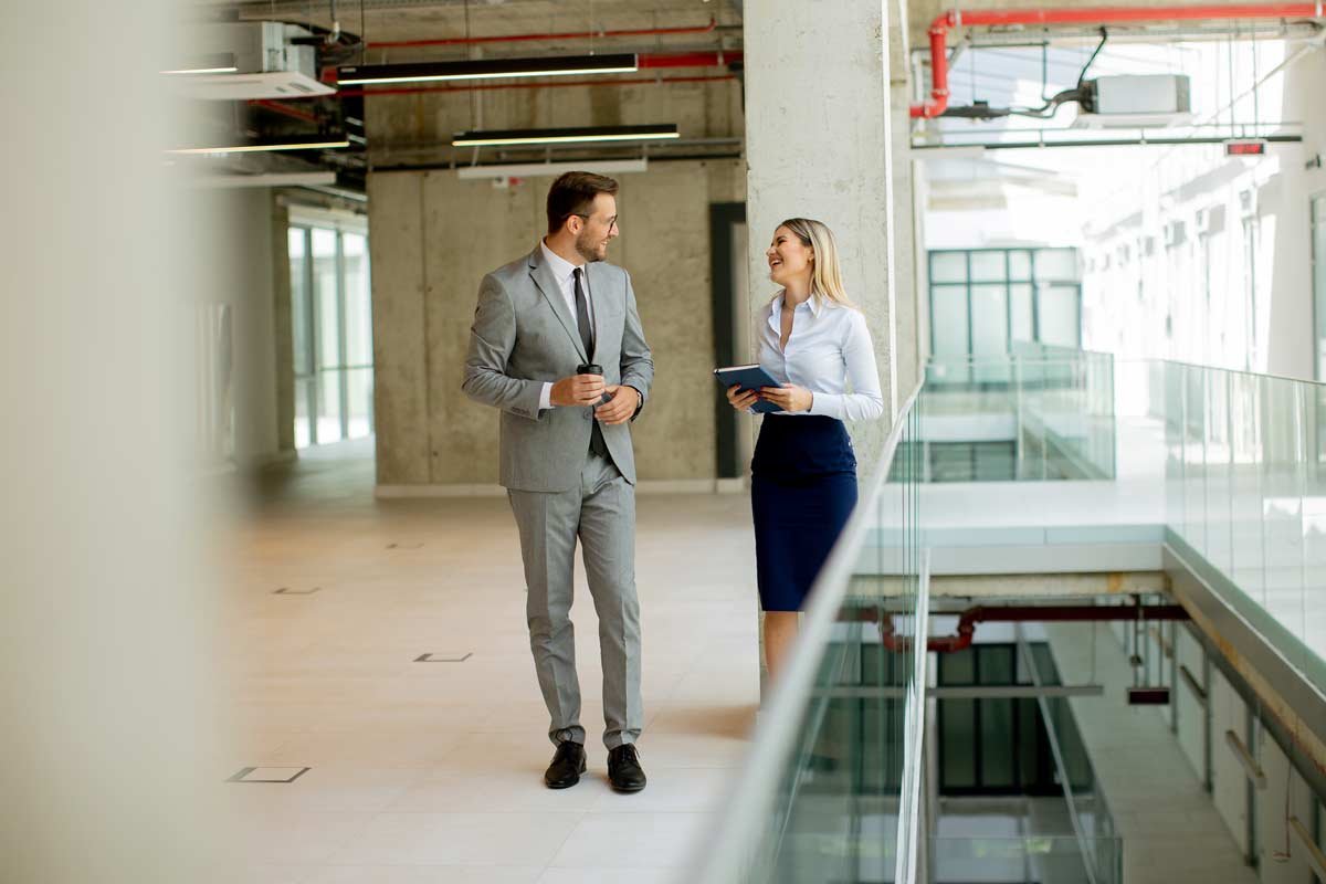 Business man, woman talking in the hallway