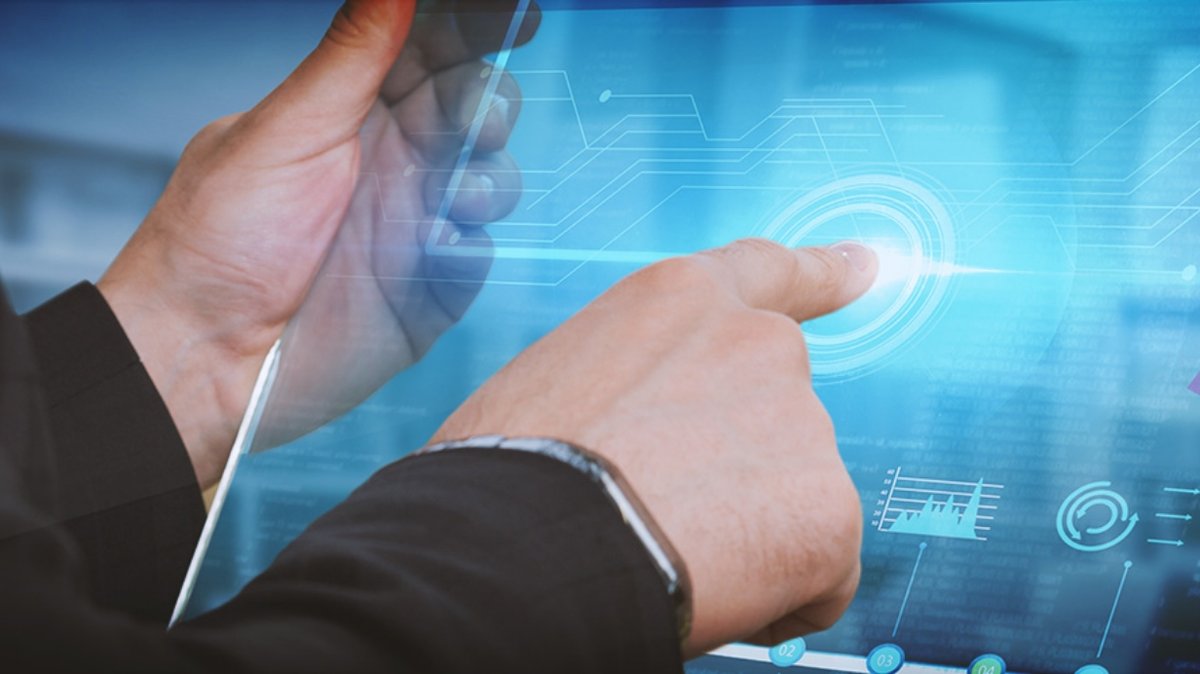 Hands holding and interacting with a futuristic clear glass computer